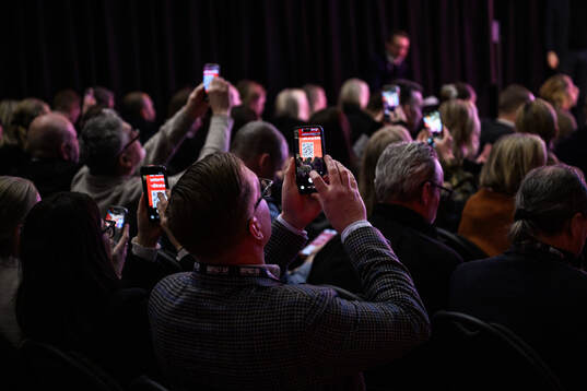 Deltagare skannar QR-kod med sina telefoner