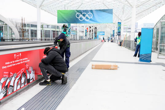 Workers are seen putting up branding at Fiera Milano