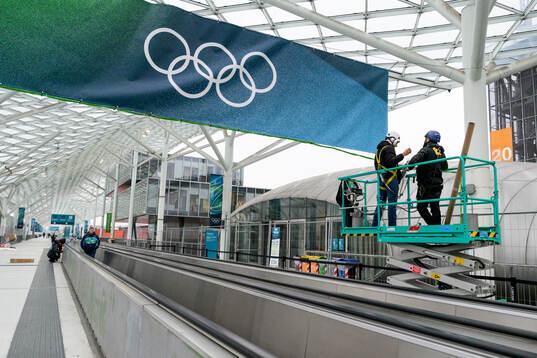 Workers are seen putting up branding at Fiera Milano