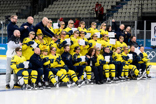 The players and staff of Sweden hold written signs in the