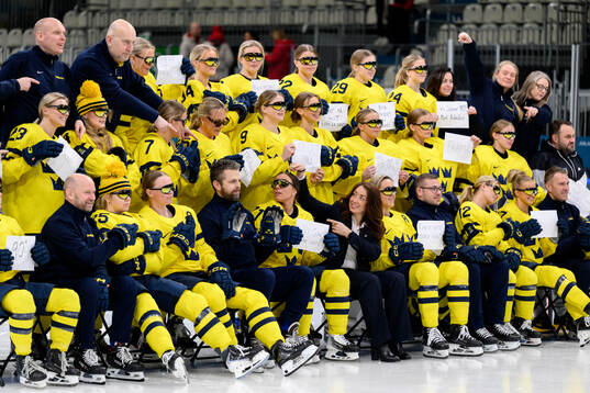 The players and staff of Sweden hold written signs in the