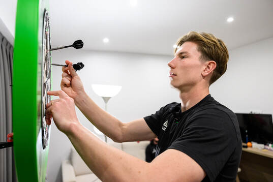 Robin Frej spelar dart på sitt hotellrum