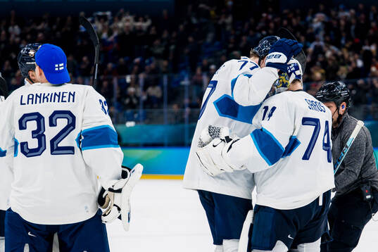 Niko Mikkola and goaltender Juuse Saros of Finland celebrate