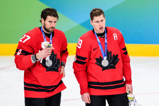 Shea Theodore and Nathan MacKinnon of Canada looks dejected