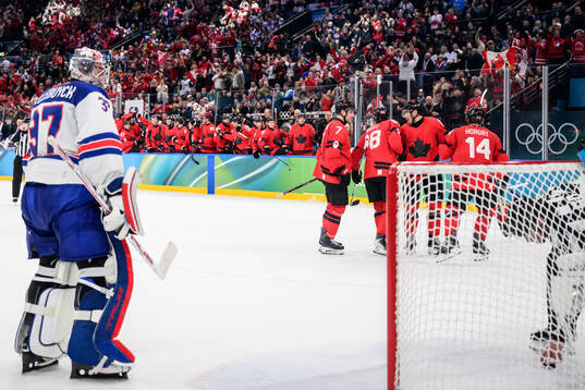 Goaltender Connor Hellebuyck of USA looks dejected and Cale