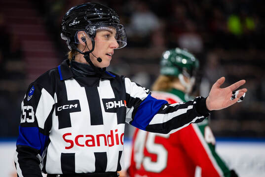 En domare med en puck i händerna