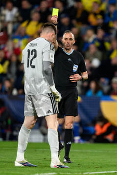 goalkeeper Anatoliy Trubin of Ukraine is shown a yellow