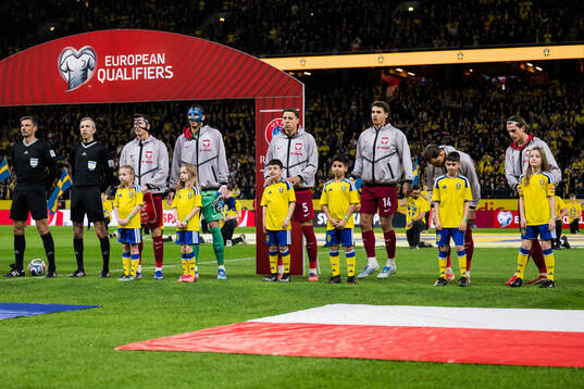 Mascots in front of Robert Lewandowski, goalkeeper Kamil