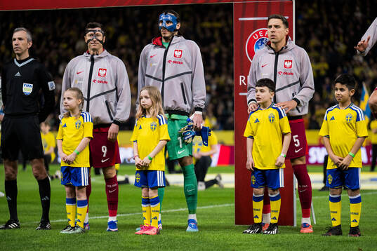 Mascots in front of Robert Lewandowski, goalkeeper Kamil
