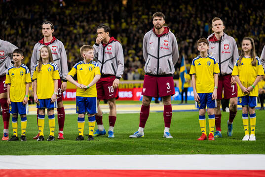 Mascots in front of Jakub Kaminski, Piotr Zielinski,