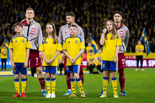 Mascots in front of Karol Swiderski, Sebastian Szymanski