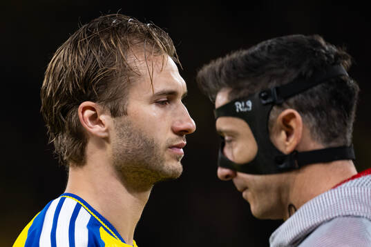 Benjamin Nygren and Robert Lewandowski of Poland