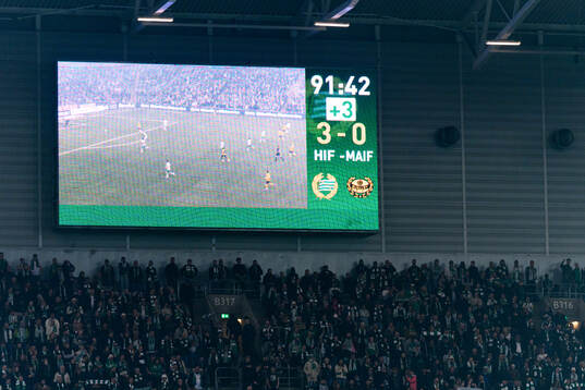 En storbildsskärm som visar matchtid och resultat