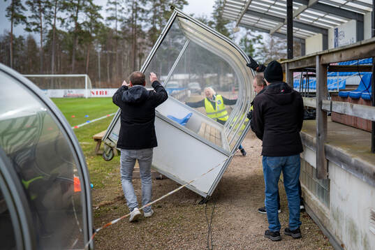Funktionärer ställer upp spelarbåsen som vältes av
