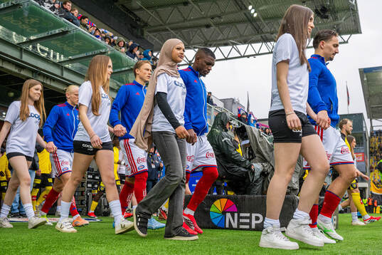 Brice Ambina and players of Vålerenga enter the pitch