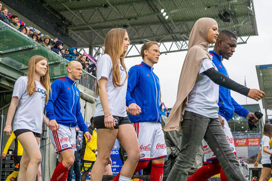 Carl Lange and players of Vålerenga enter the pitch