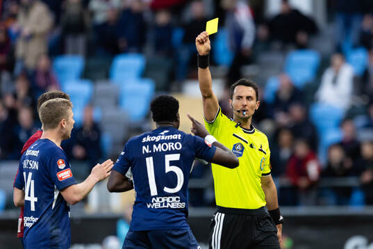 Degerfors Nasiru Moro får ett gult kort av Domare Adi
