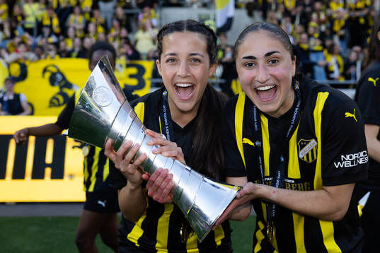 Delaney Matriano and Nesrin Akgun celebrate with the trophy