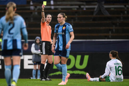 Domare Lovisa Johansson ger ett gult kort till Djurgårdens