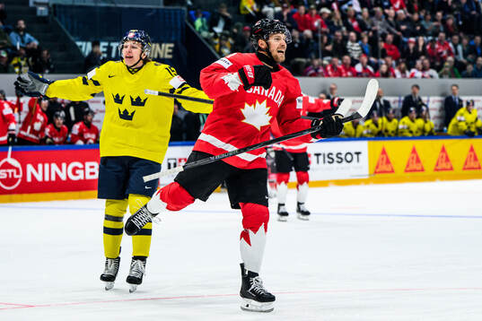 Dylan Holloway of Canada celebrates and Jack Berglund of