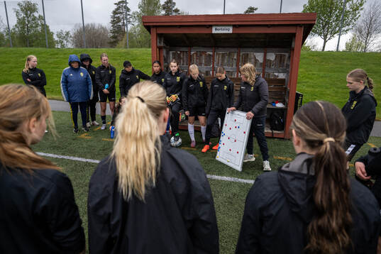 En instruktör från Svenska Fotbollsförbundet lyssnar på