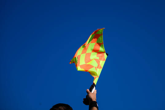Linjedomare med flagga för offside