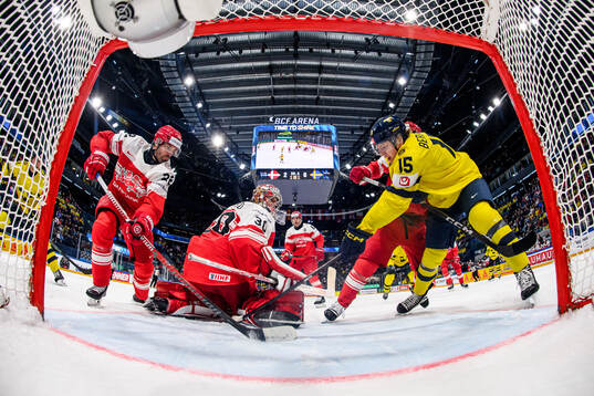 Markus Lauridsen and goaltender Mads Søgaard of Denmark