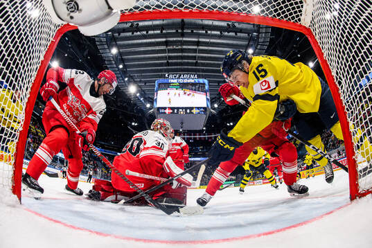 Markus Lauridsen and goaltender Mads Søgaard of Denmark