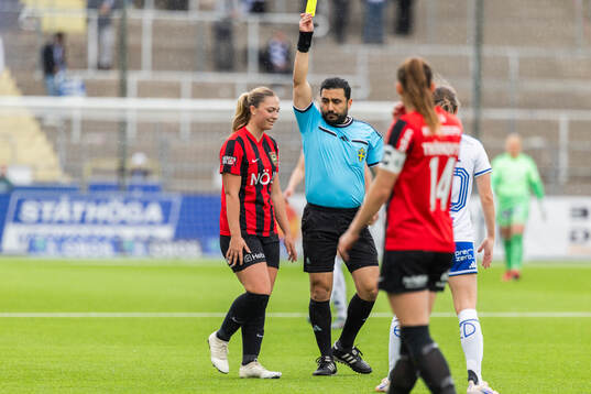Domare Paul Shamoun delar ut ett gult kort till