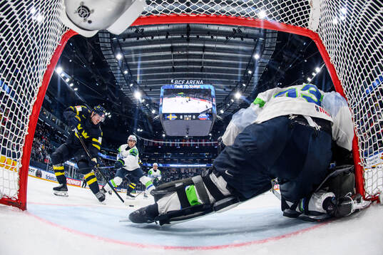 Carl Grundström of Sweden and goaltender Zan Us of Slovenia
