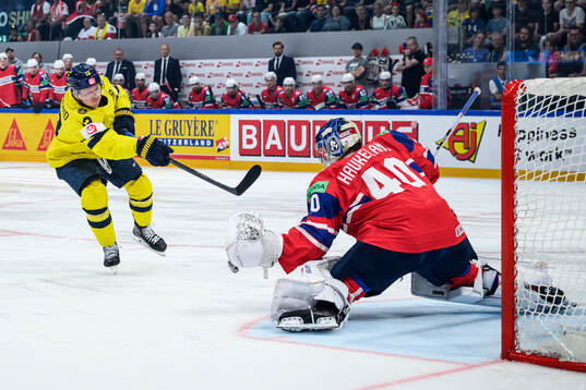 Lucas Raymond of Sweden and goaltender Henrik Haukeland of