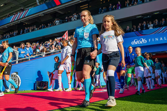 Assistant referee Monica Løkkeberg enters the pitch