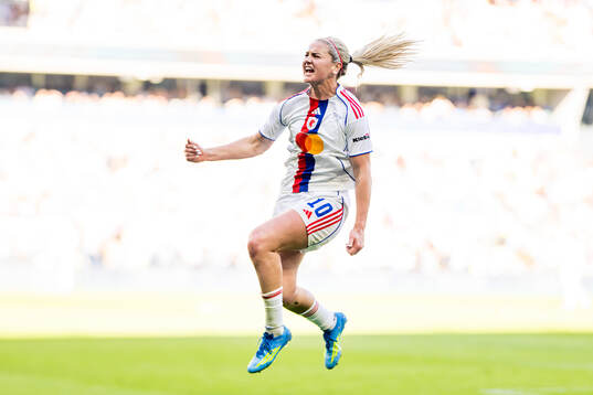Lindsey Heaps of Lyon celebrates scoring a goal later being