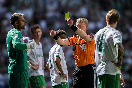 Domare Adam Ladebäck ger ett gult kort till Hammarbys