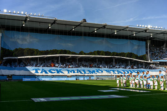 Malmö FFs spelare framför ett tifo