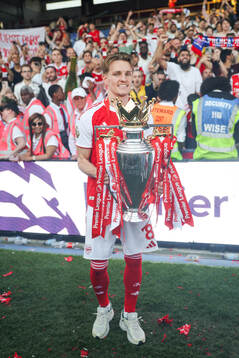 Martin Ødegaard of Arsenal celebrates with the trophy for