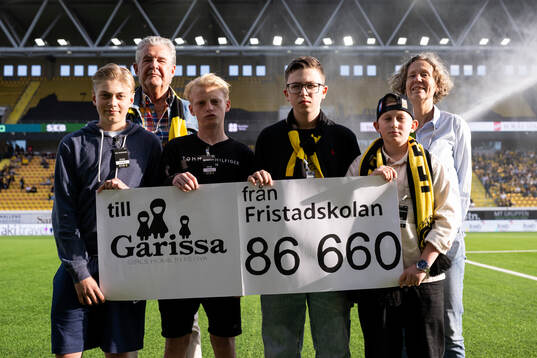 Elever från Fristadskolan överlämnar en värdecheck till