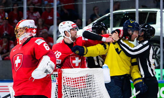 Sven Jung of Switzerland and goaltender Arvid Söderblom of