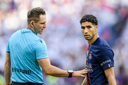 Referee Daniel Siebert and Achraf Hakimi of Paris