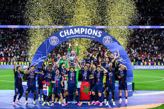 Players of Paris Saint-Germain celebrate with the trophy