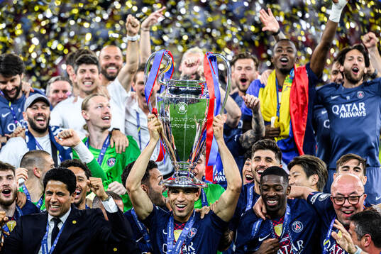 Players of Paris Saint-Germain celebrate with the trophy