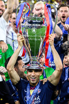 Players of Paris Saint-Germain celebrate with the trophy