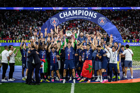 Players of Paris Saint-Germain celebrate with the trophy