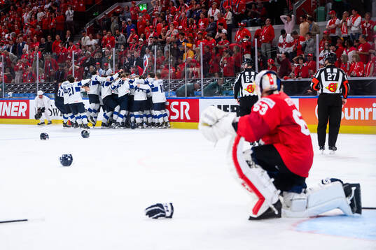 Players of Finland celebrate winning and Leonardo Genoni of