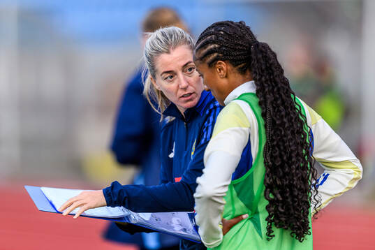 Assistant coach Linda Sembrandt and Cassandra Bogere of