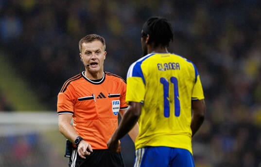 Referee Aaron Wyn Jones and Anthony Elanga of Sweden