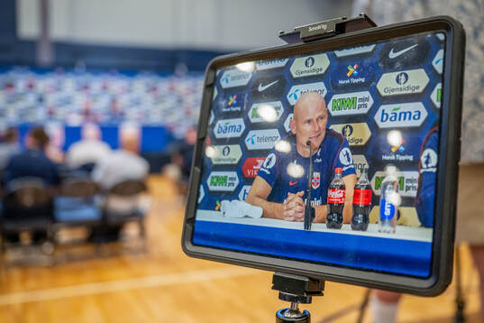 A screen shows head coach Ståle Solbakken of the Norwegian