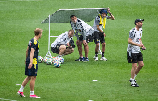 Staff hide from the rain at a training session with the