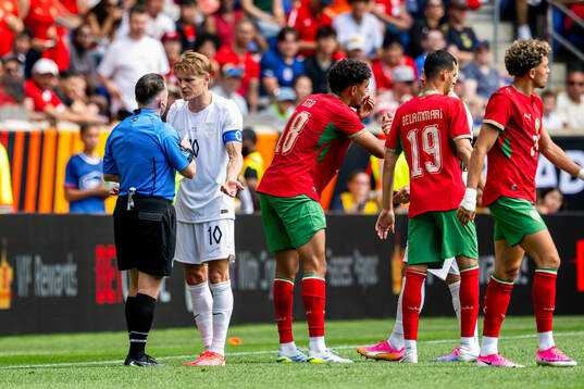 Martin Ødegaard of Norway argues with the referee