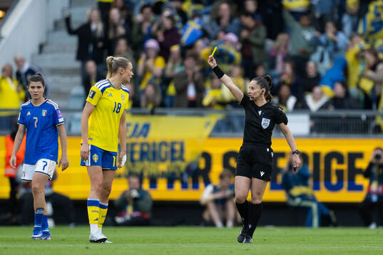 Fridolina Rolfö of Sweden receives a yellow card from
